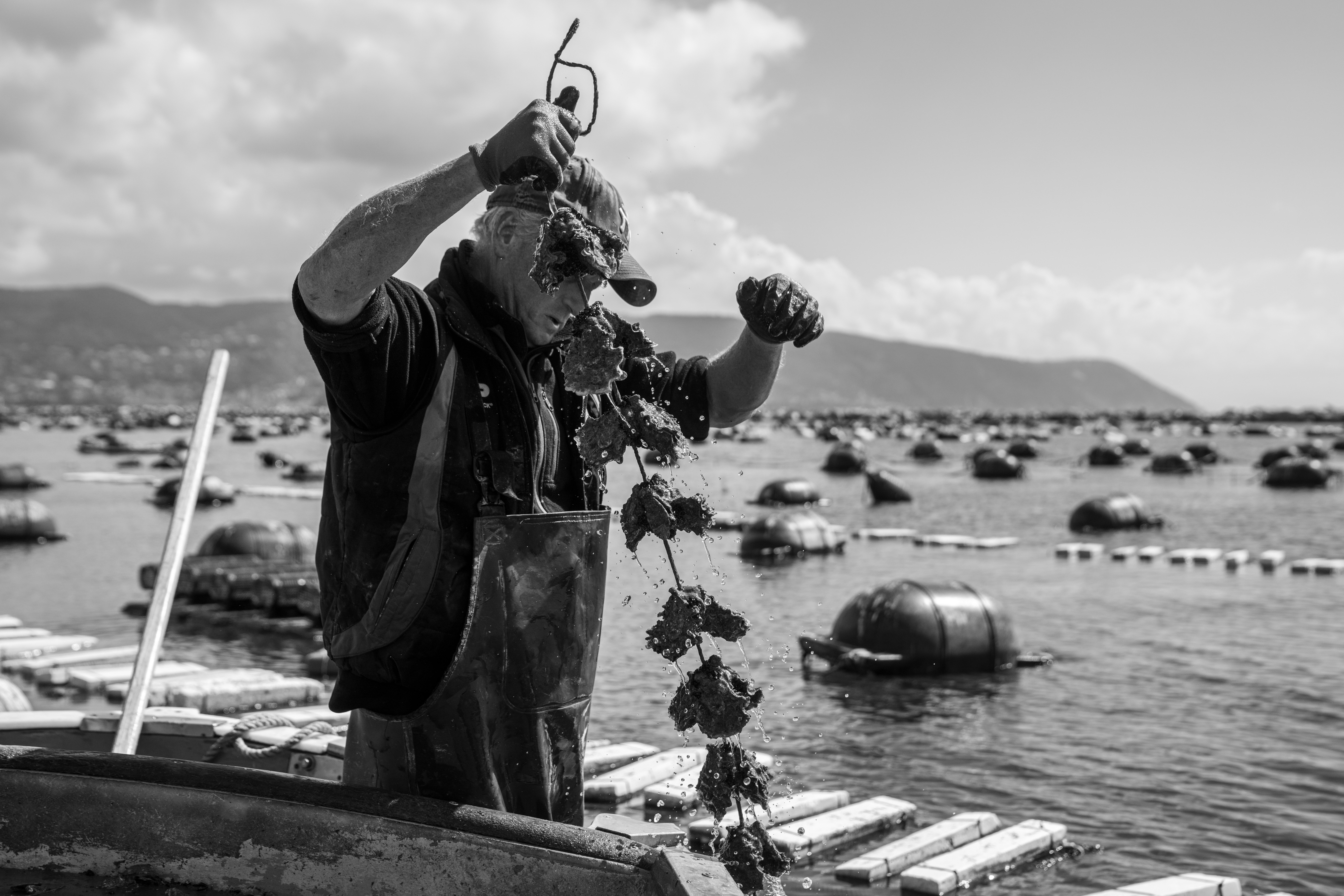 A black and white photo of a man on a boat