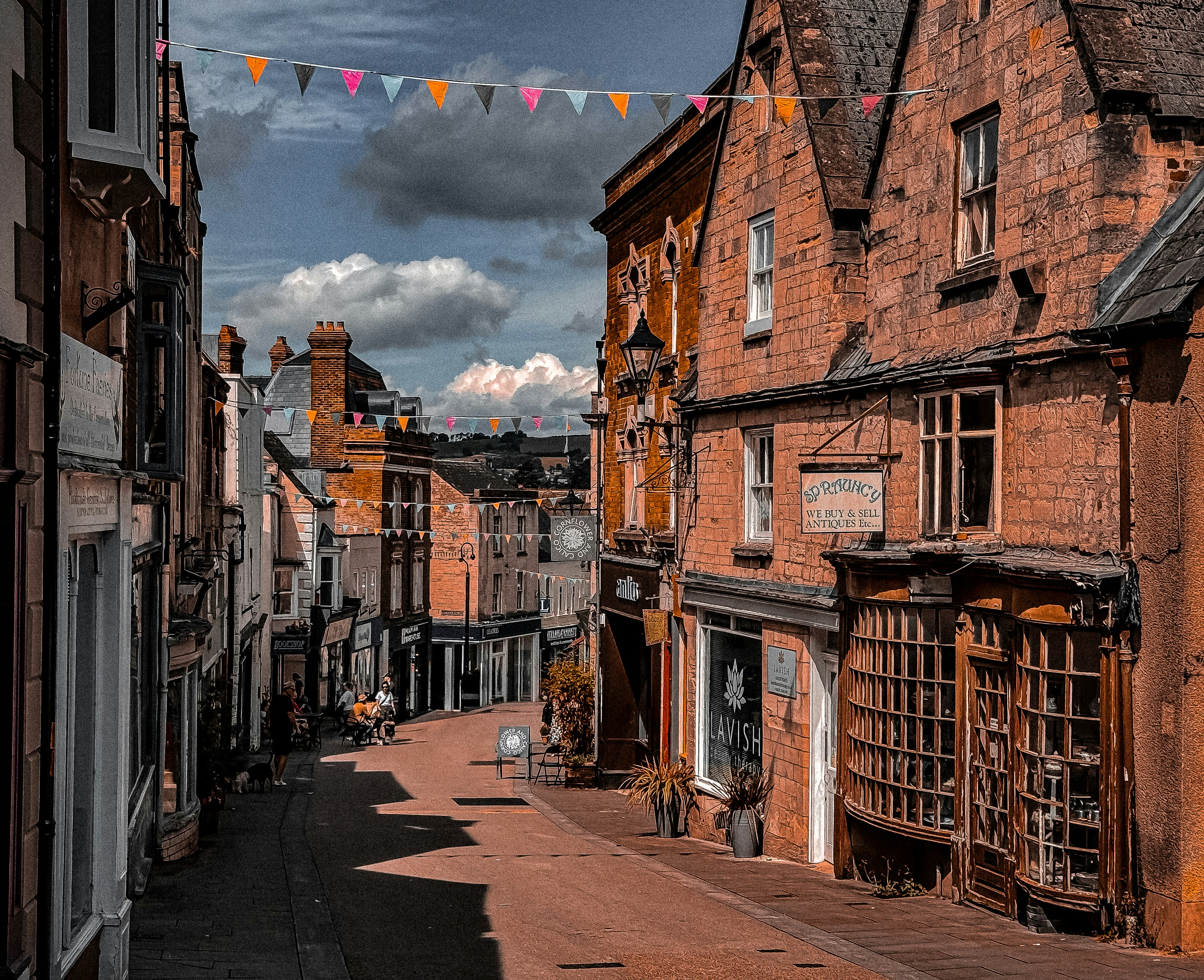 A street lined with tall brick buildings under a cloudy sky
