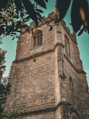 A tall brick tower with a clock on it's side