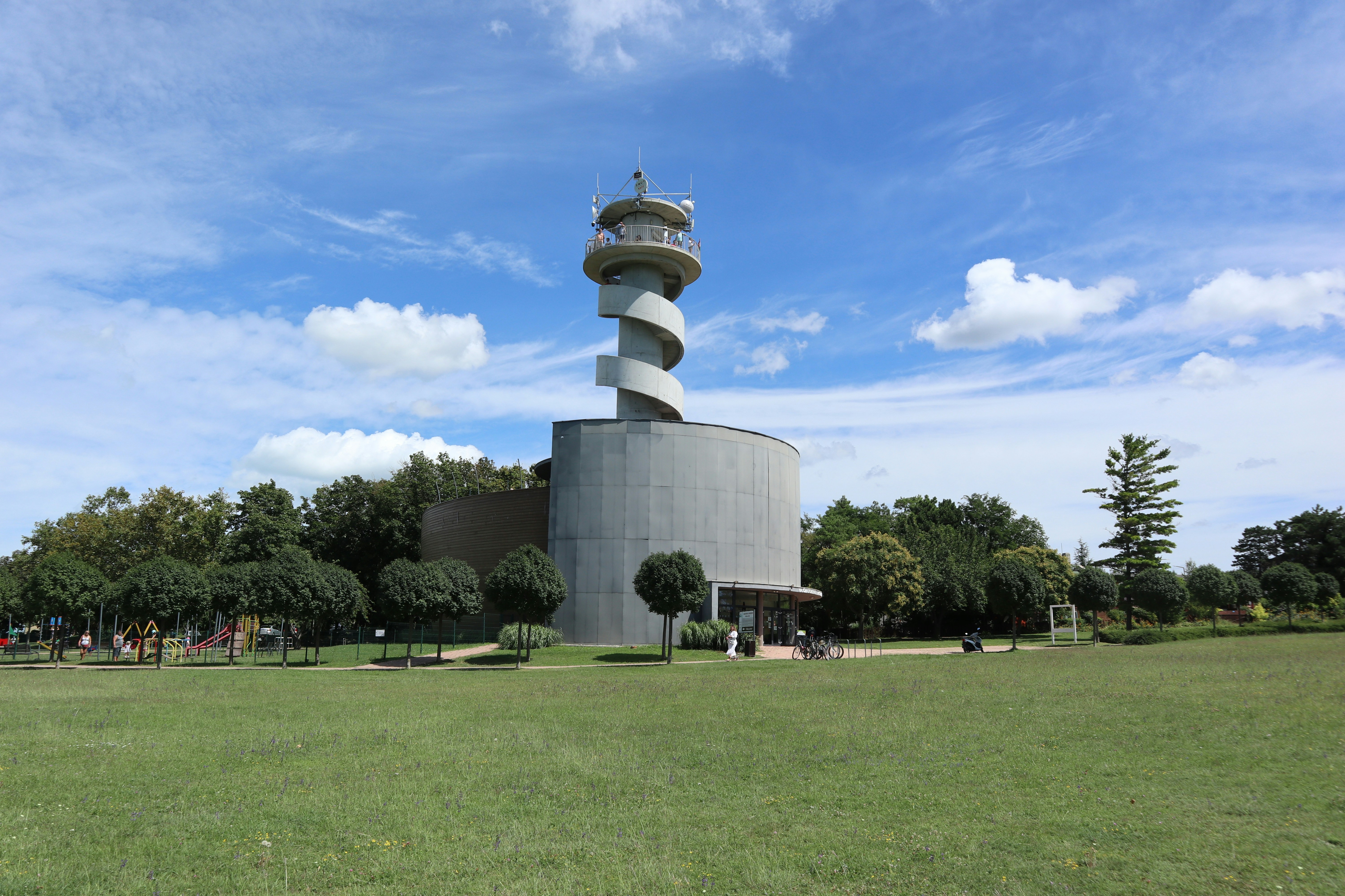 A tall tower sitting in the middle of a lush green field