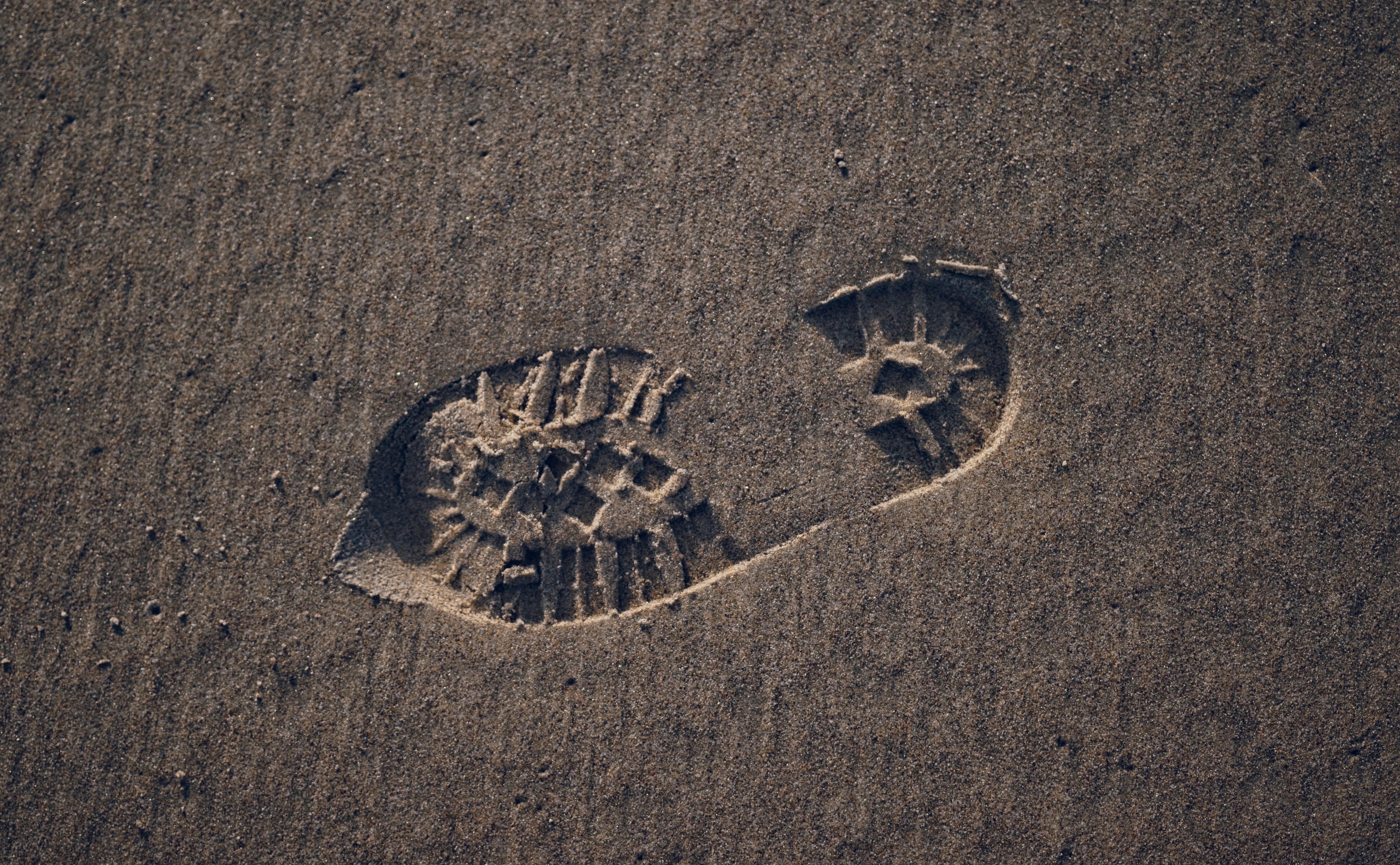Two footprints in the sand of a beach