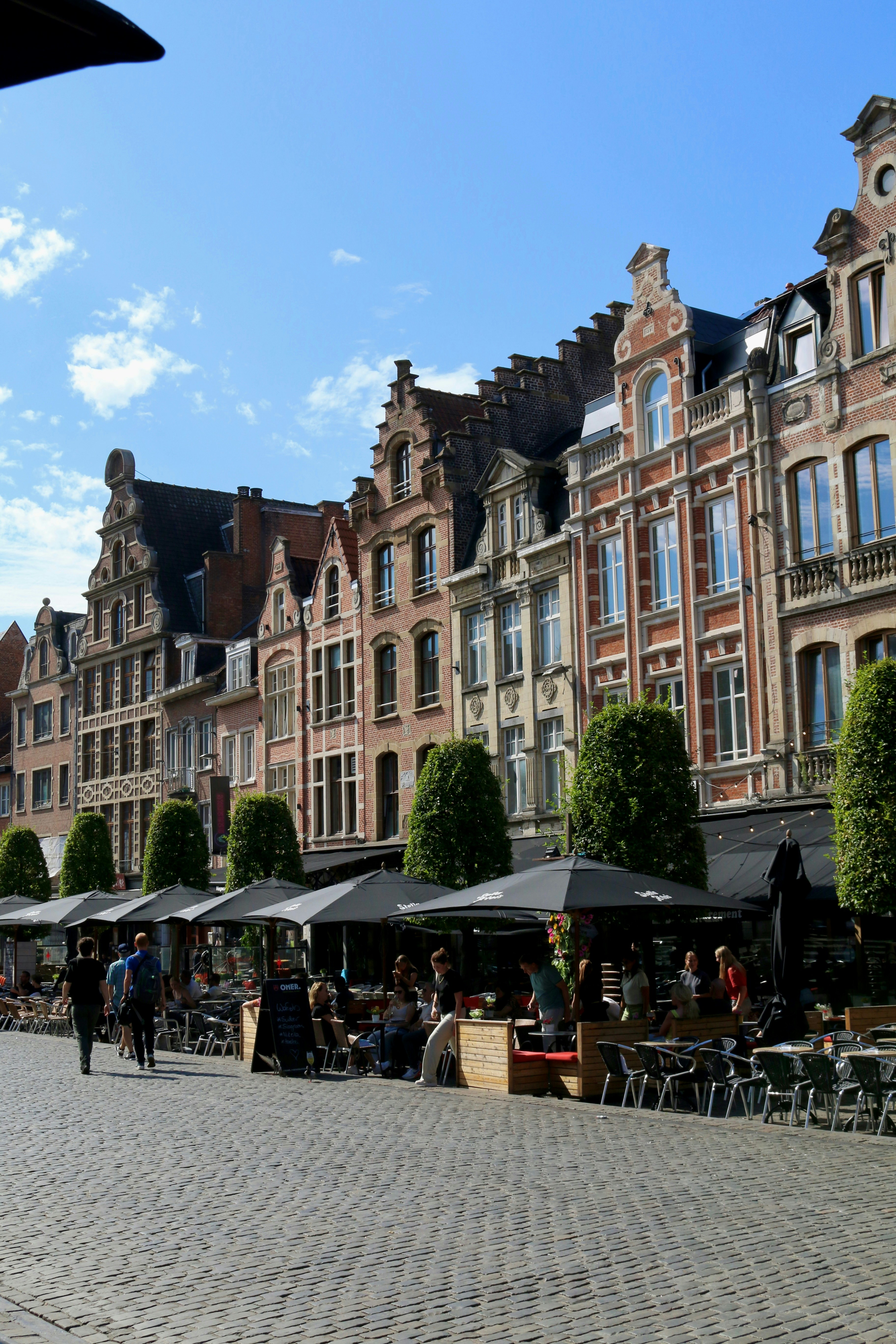 Un groupe de personnes assises à des tables devant des bâtiments