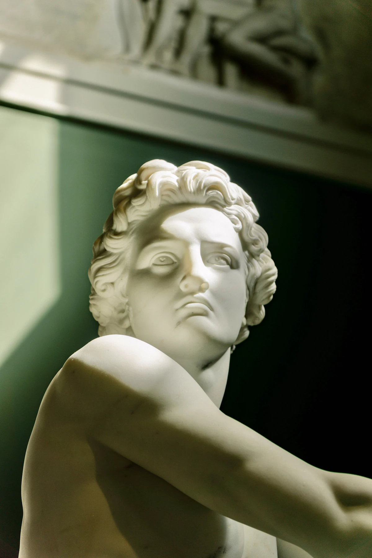 A marble statue of a classical figure in soft window light