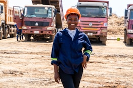 A young boy standing in front of a group of trucks