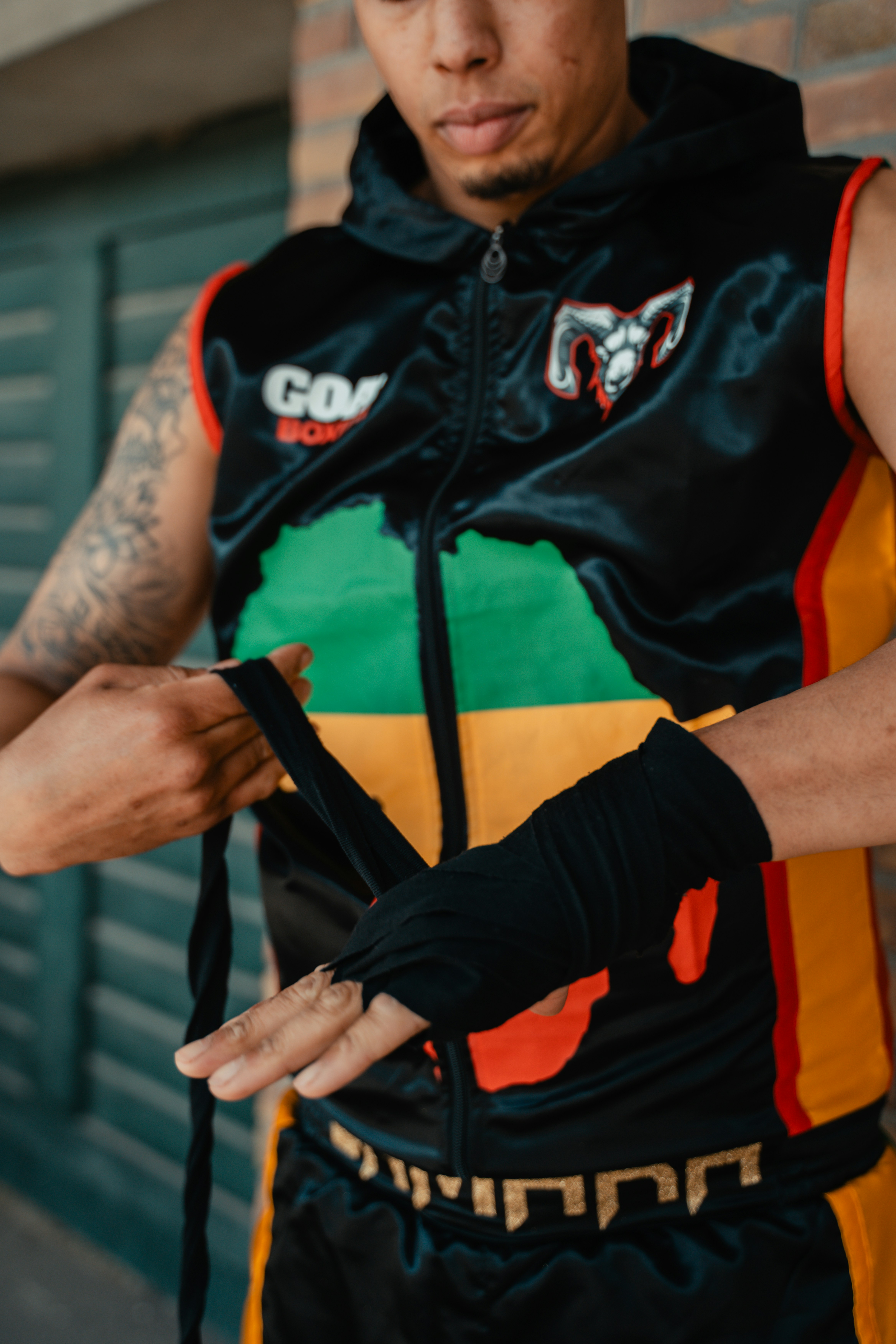 A man with a tattoo on his arm wearing a colorful vest