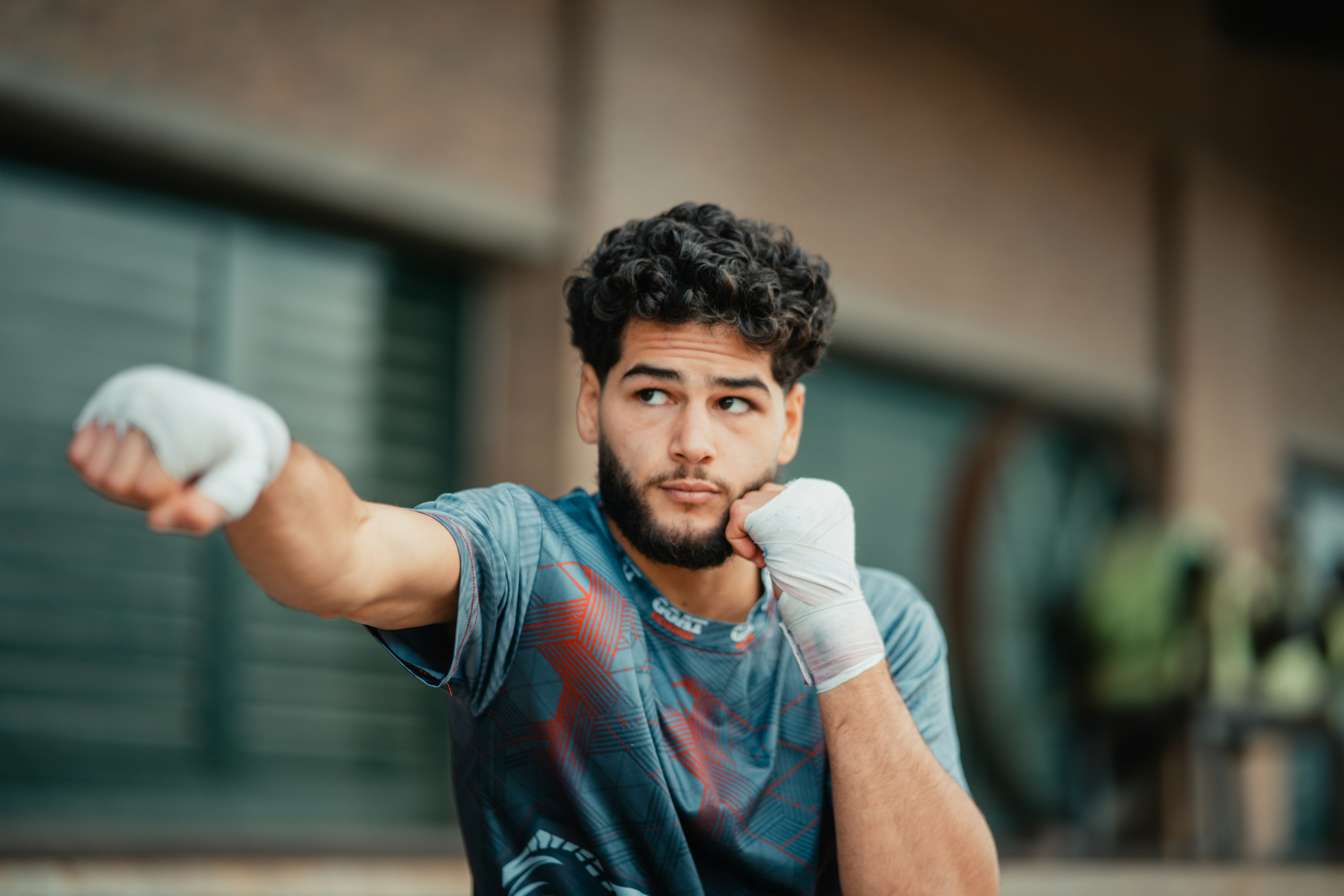 Boxer practicing punches with wrapped hands, illustrating proper hand wrapping technique in context of boxing training.