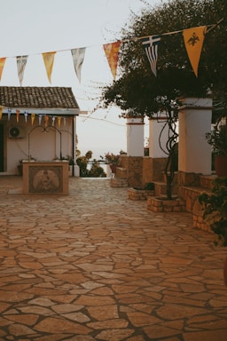 A cobblestone patio with flags and potted plants