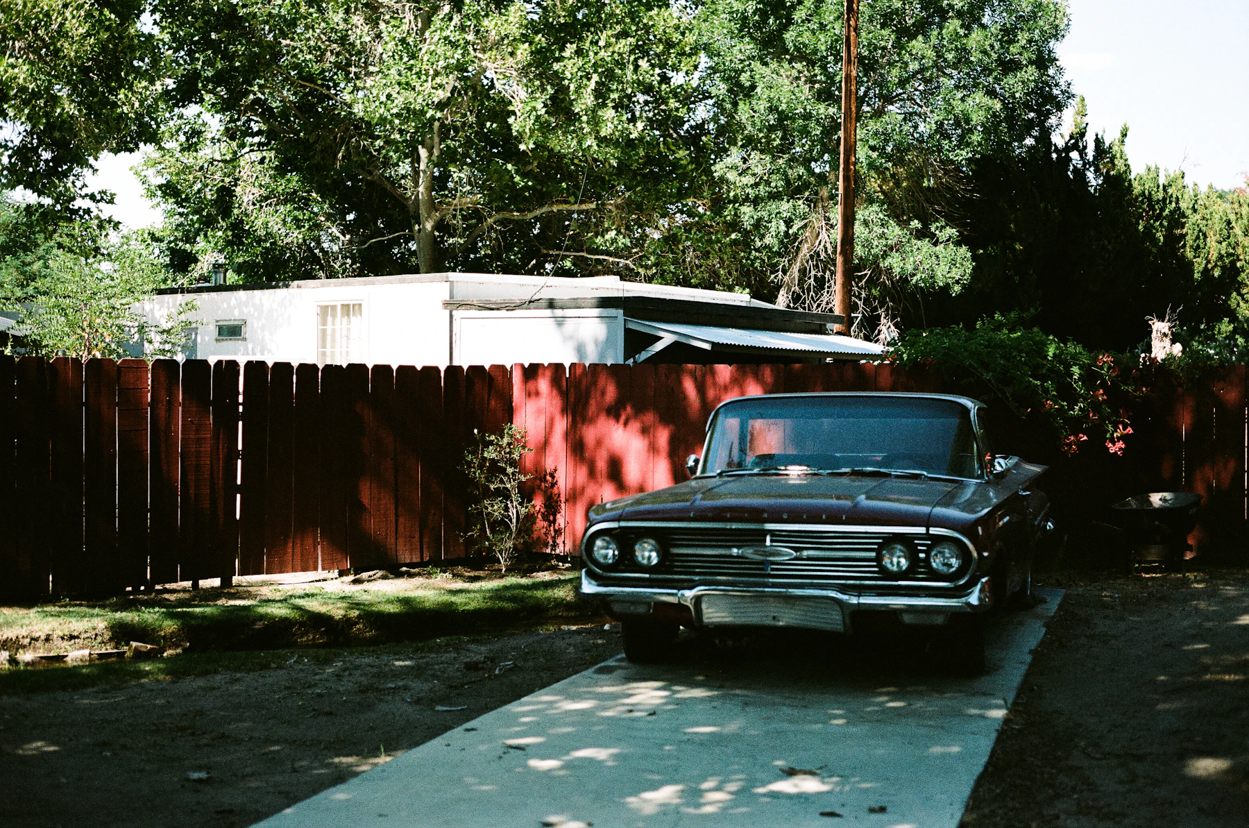 Car parked on a residential paved driveway beside a house