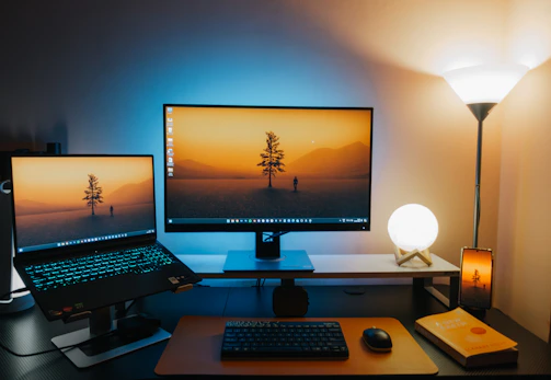 A computer desk with two monitors and a keyboard