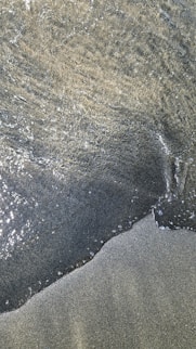 A close up of the sand and water on a beach
