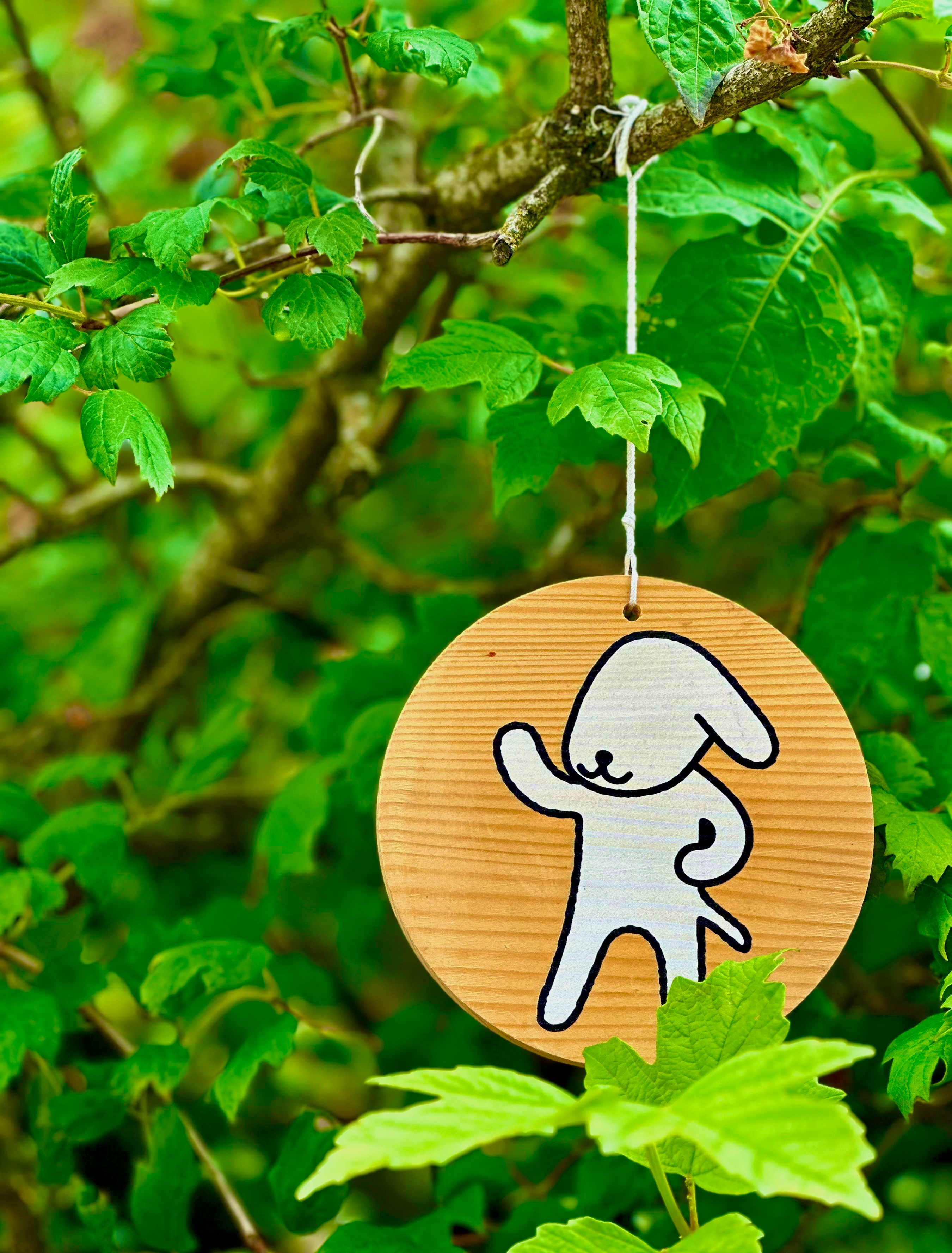 A wooden ornament hanging from a tree