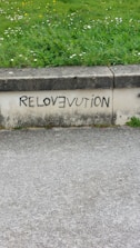 A sidewalk with graffiti on the side of it