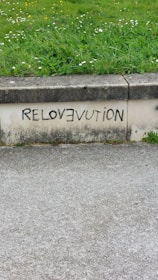 A sidewalk with graffiti on the side of it