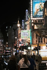 A group of people walking down a street at night