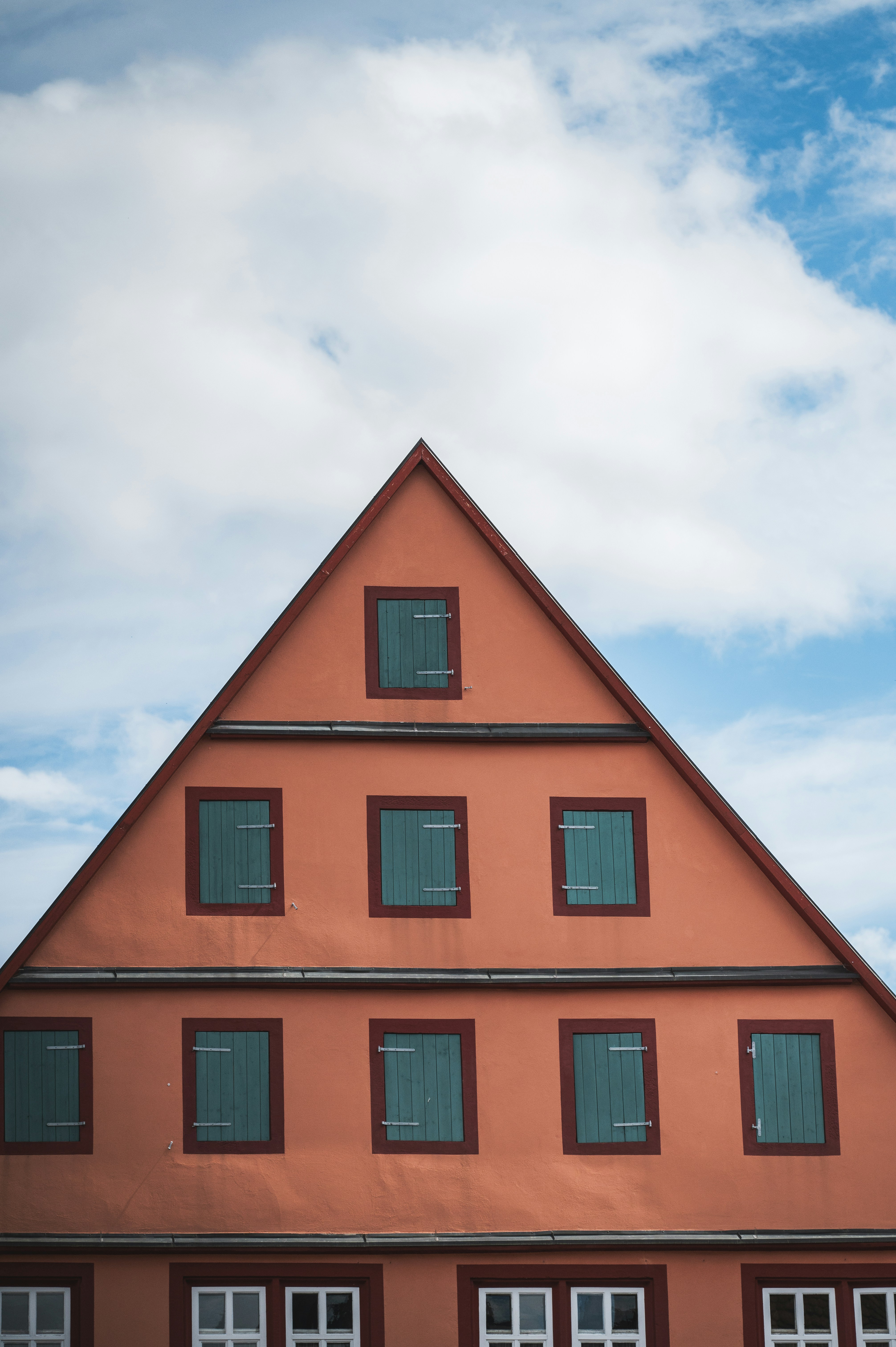 A red building with windows and a sky background