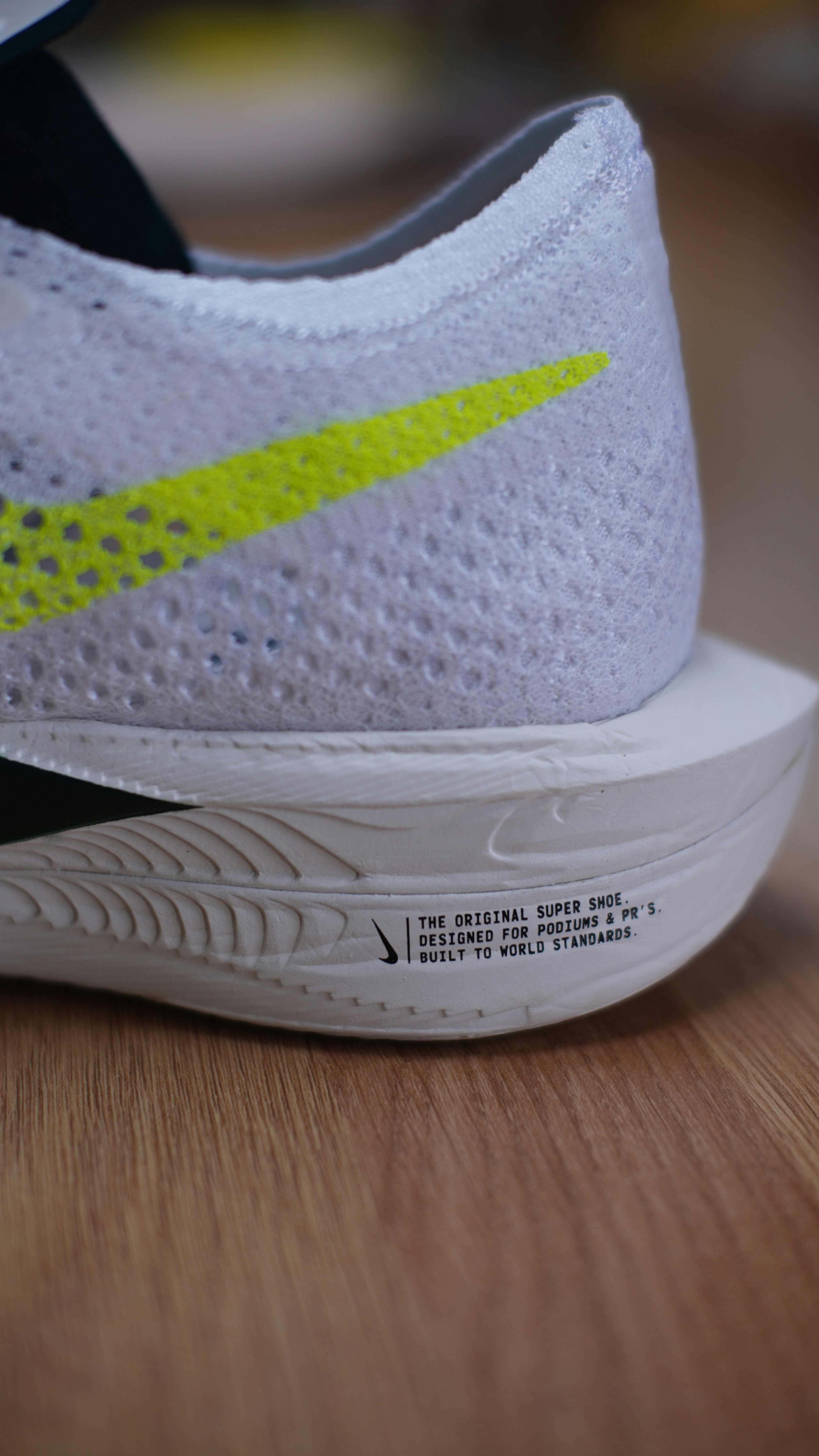 A close up of a shoe on a wooden surface