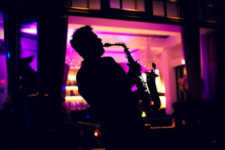 A man playing a saxophone in a dark room