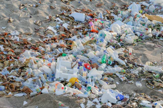 A pile of trash sitting on top of a sandy beach
