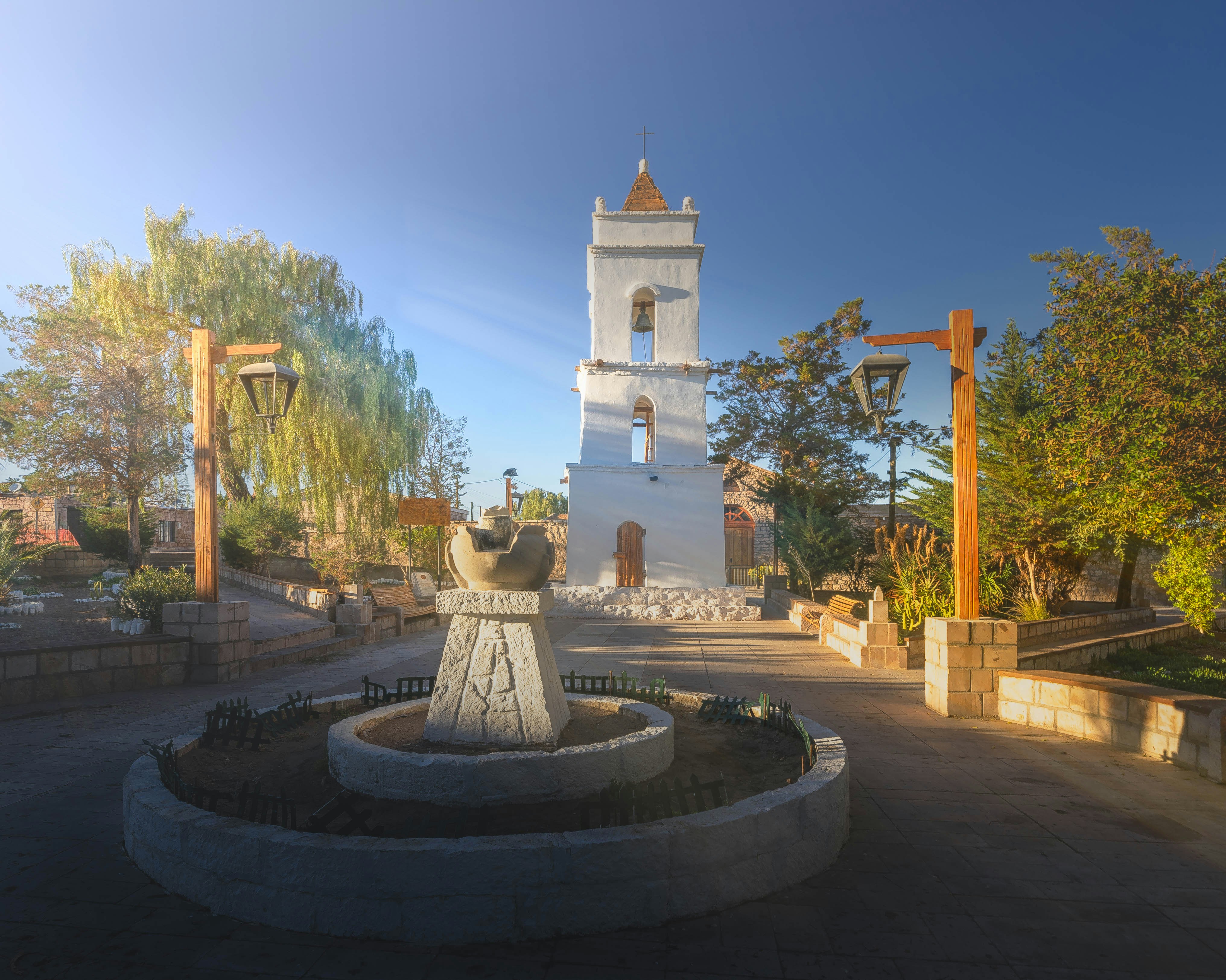 A white clock tower sitting in the middle of a park