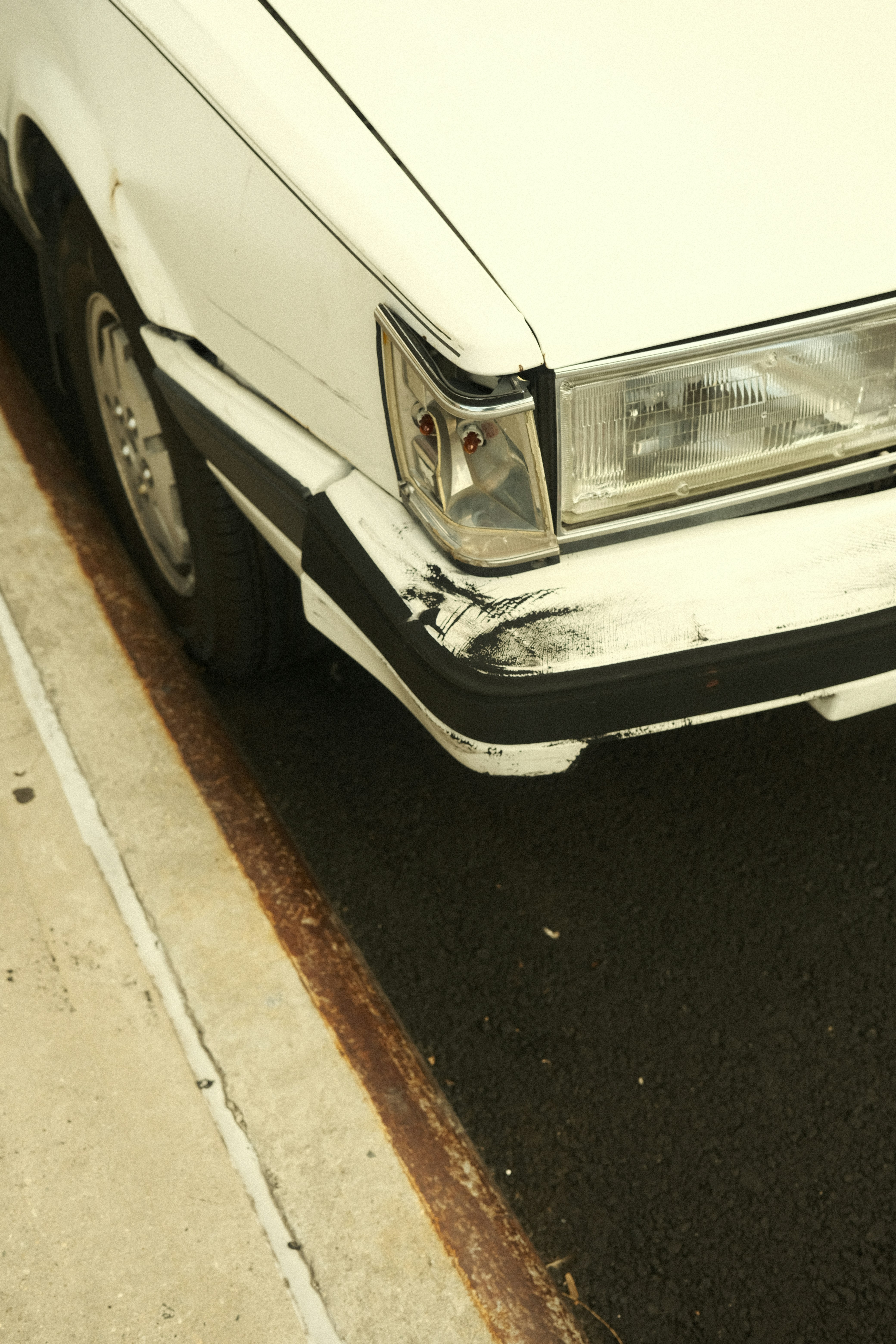 A white car parked on the side of the road