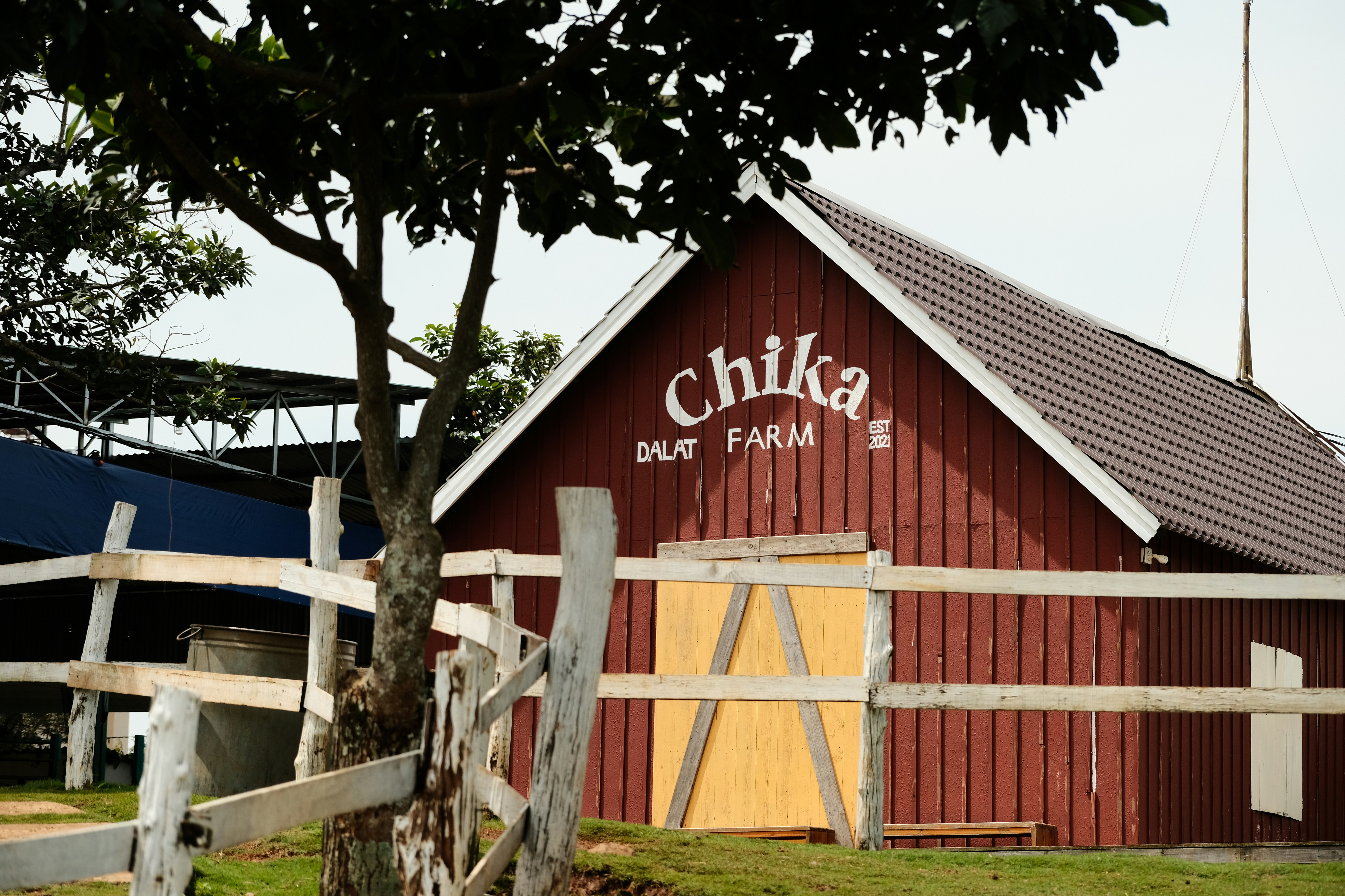 A red barn with a white fence around it