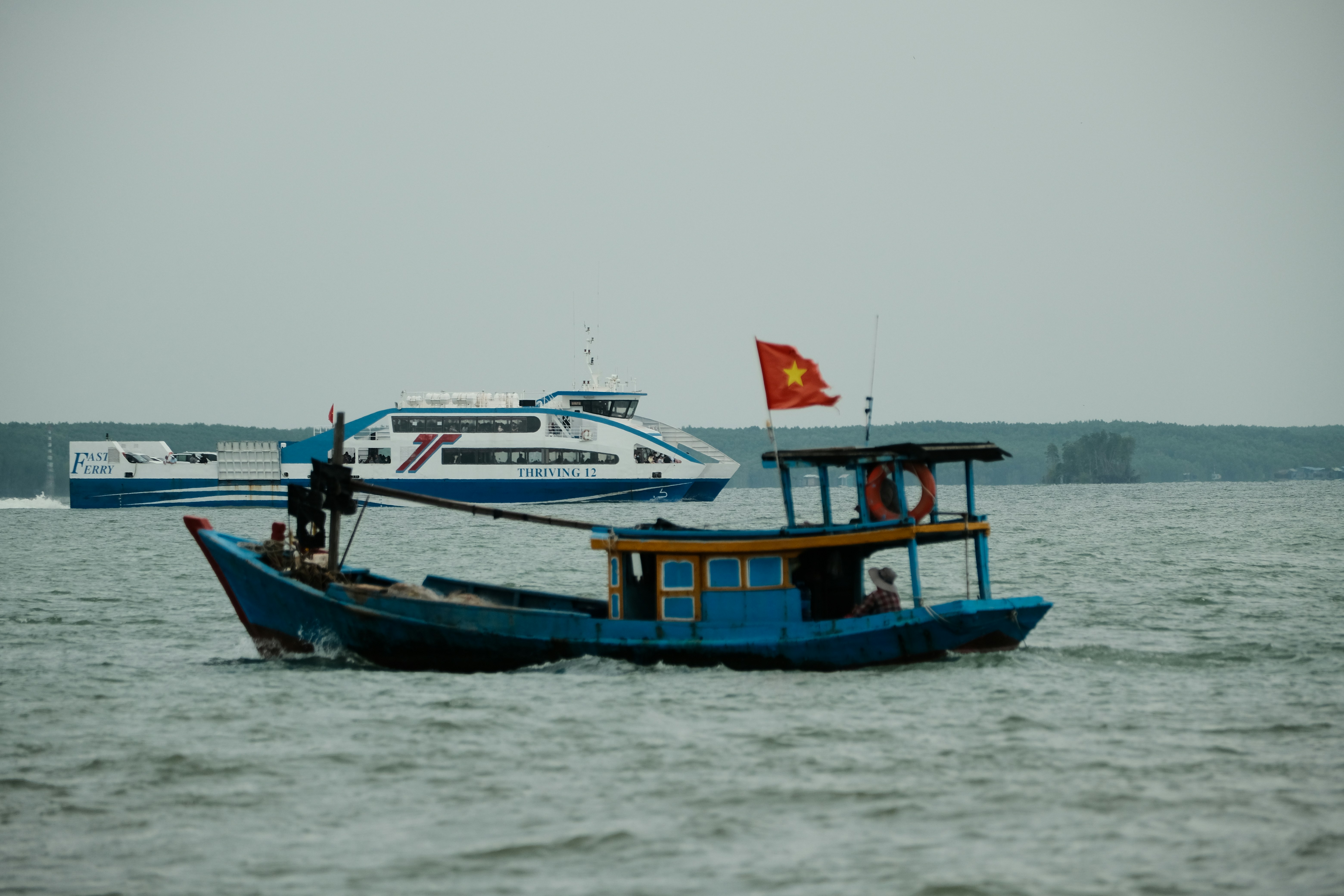 A blue boat with a red flag is in the water