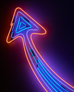 A neon sign with an arrow pointing to the right