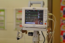 A hospital room with a monitor on a tripod
