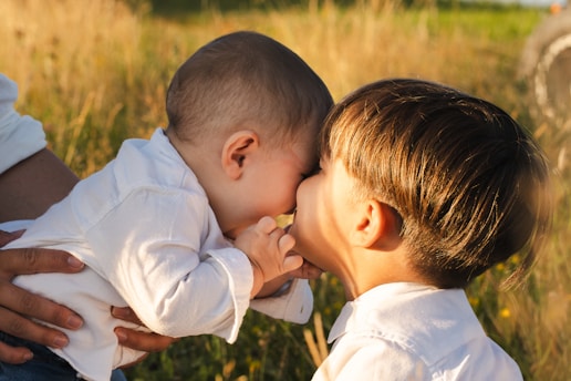 A woman holding a baby and kissing it's face