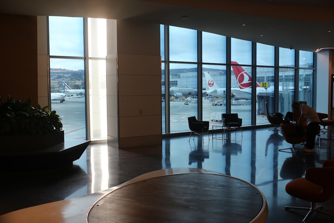 A room with a large window and a table with chairs,