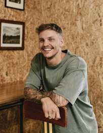A man sitting at a table with a pool cue in his hand