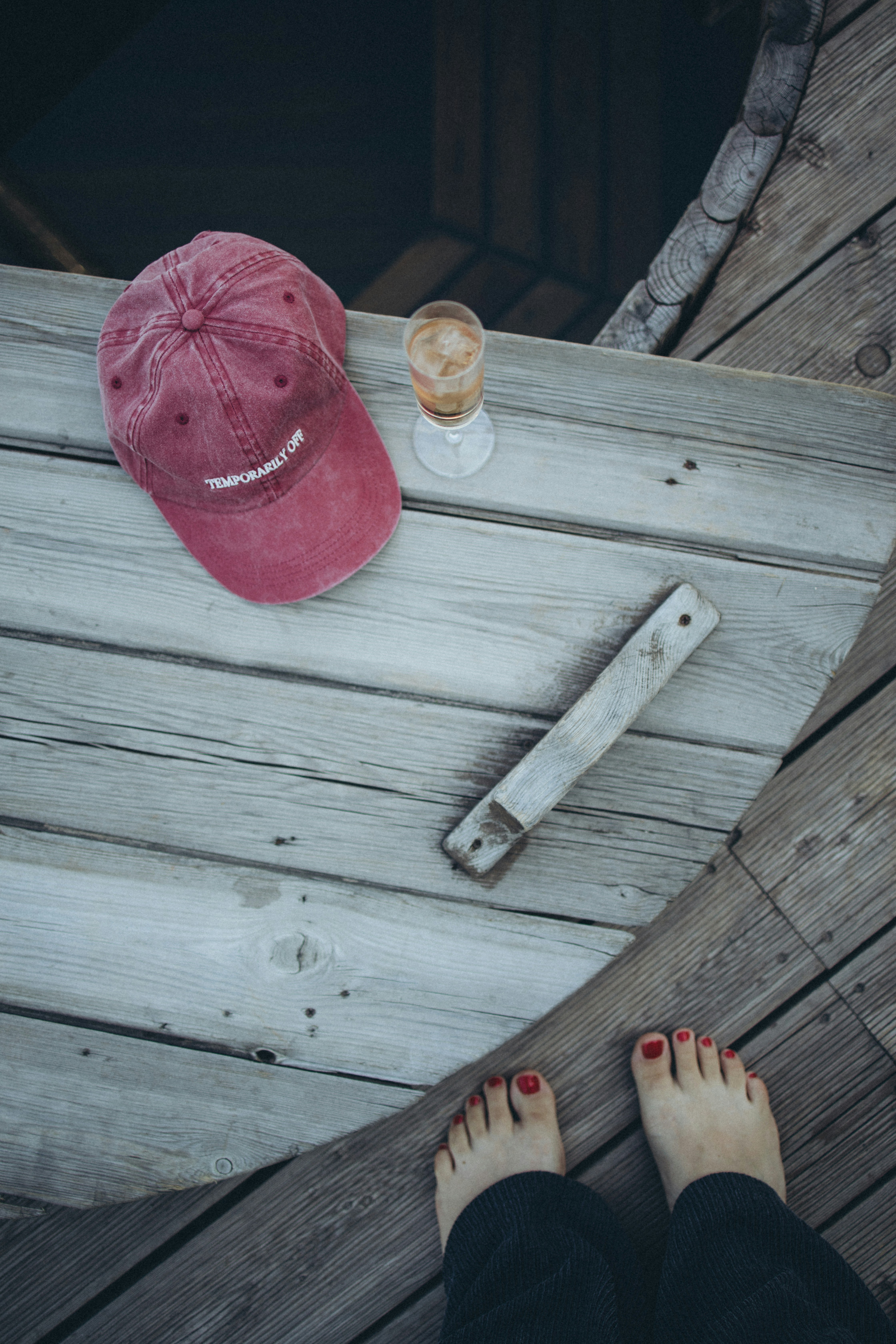 A person standing on a wooden floor next to a hat
