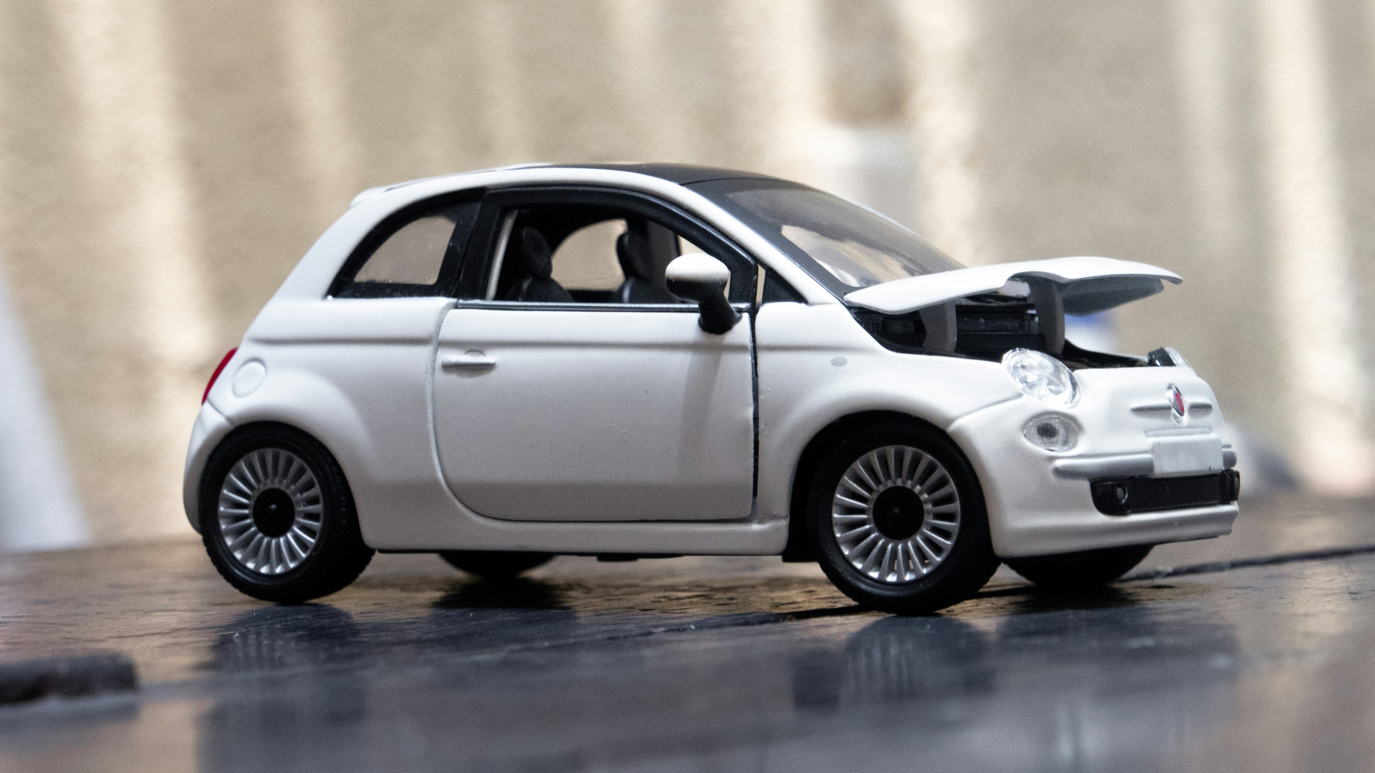 A small white car with a surfboard on top of it