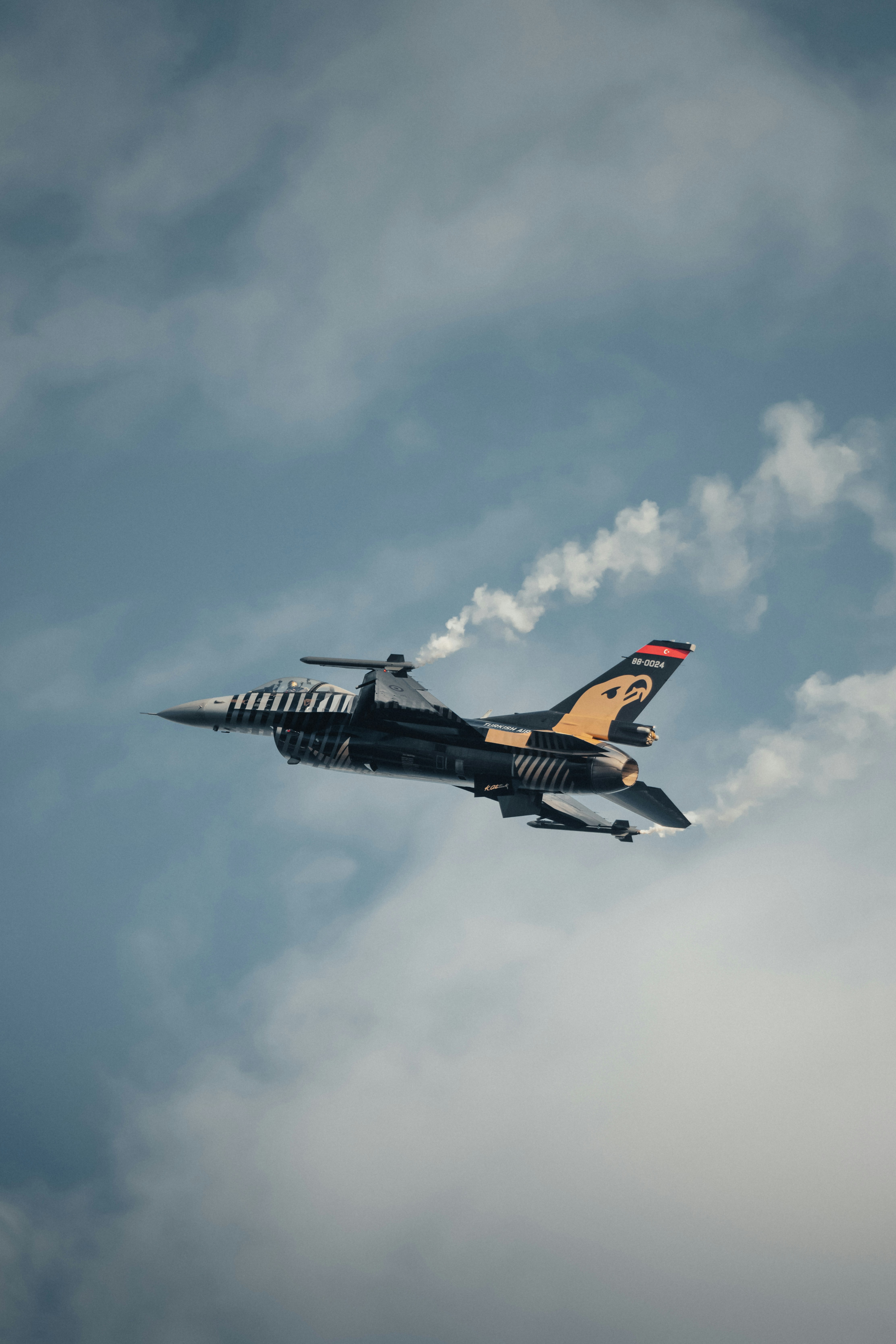 A fighter jet flying through a cloudy sky