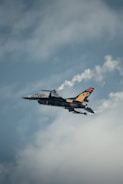 A fighter jet flying through a cloudy sky