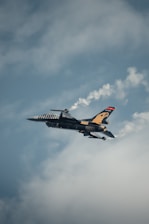 A fighter jet flying through a cloudy sky