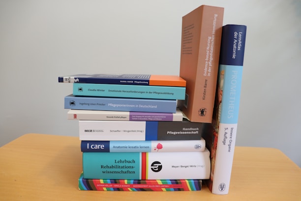 A stack of books sitting on top of a wooden table