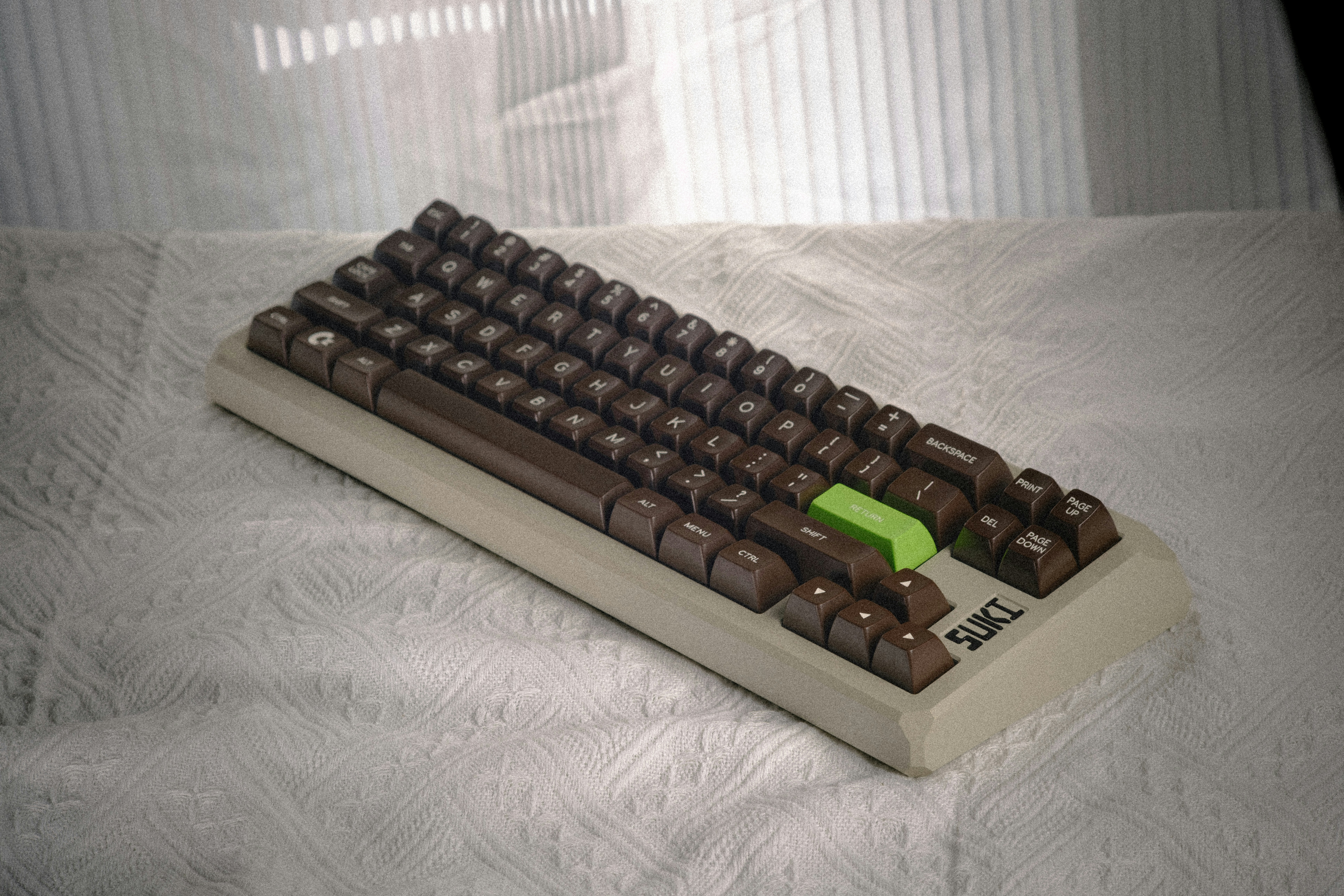 A computer keyboard sitting on top of a bed