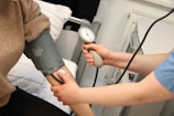 A person with a blood pressure device in their hand