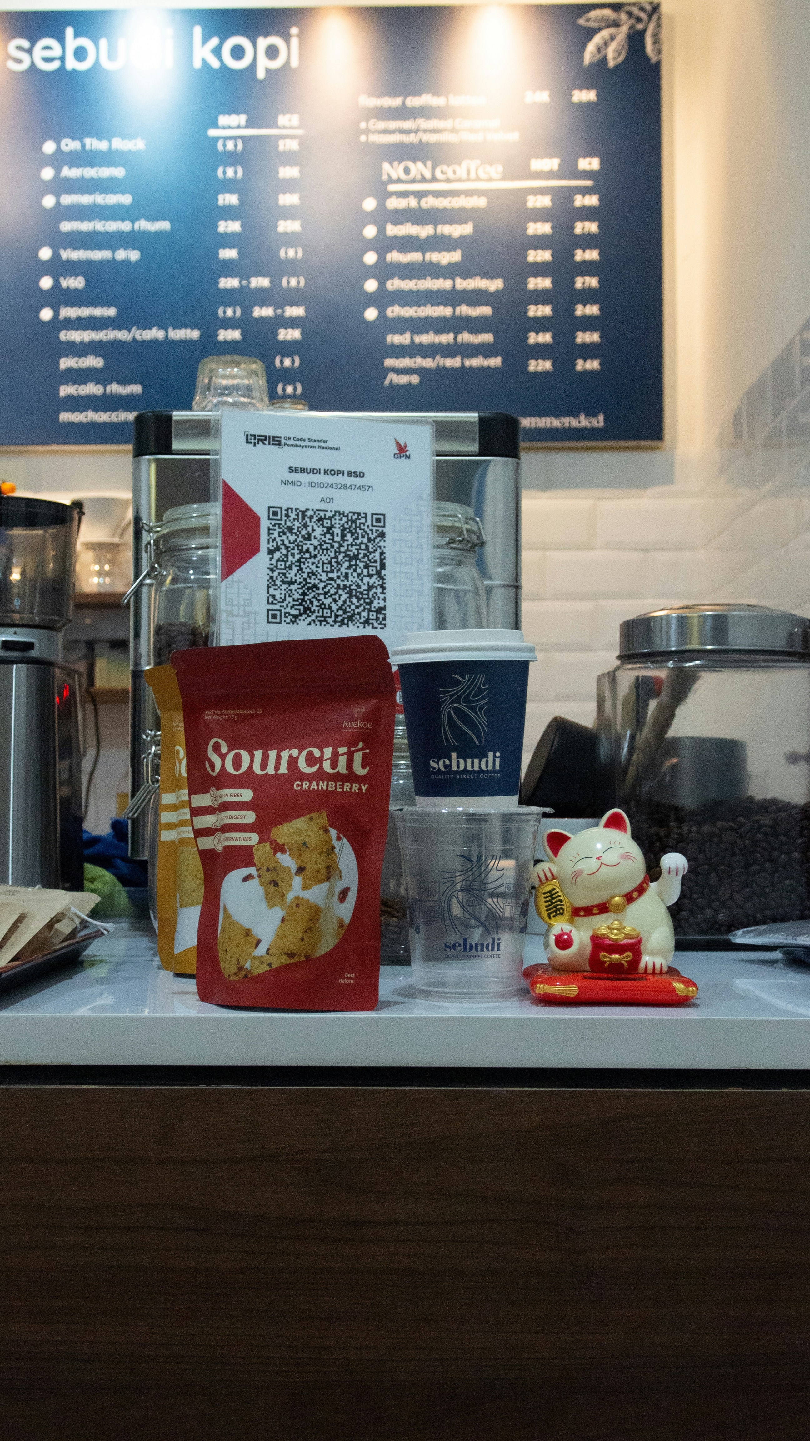 A coffee shop counter with a menu behind it