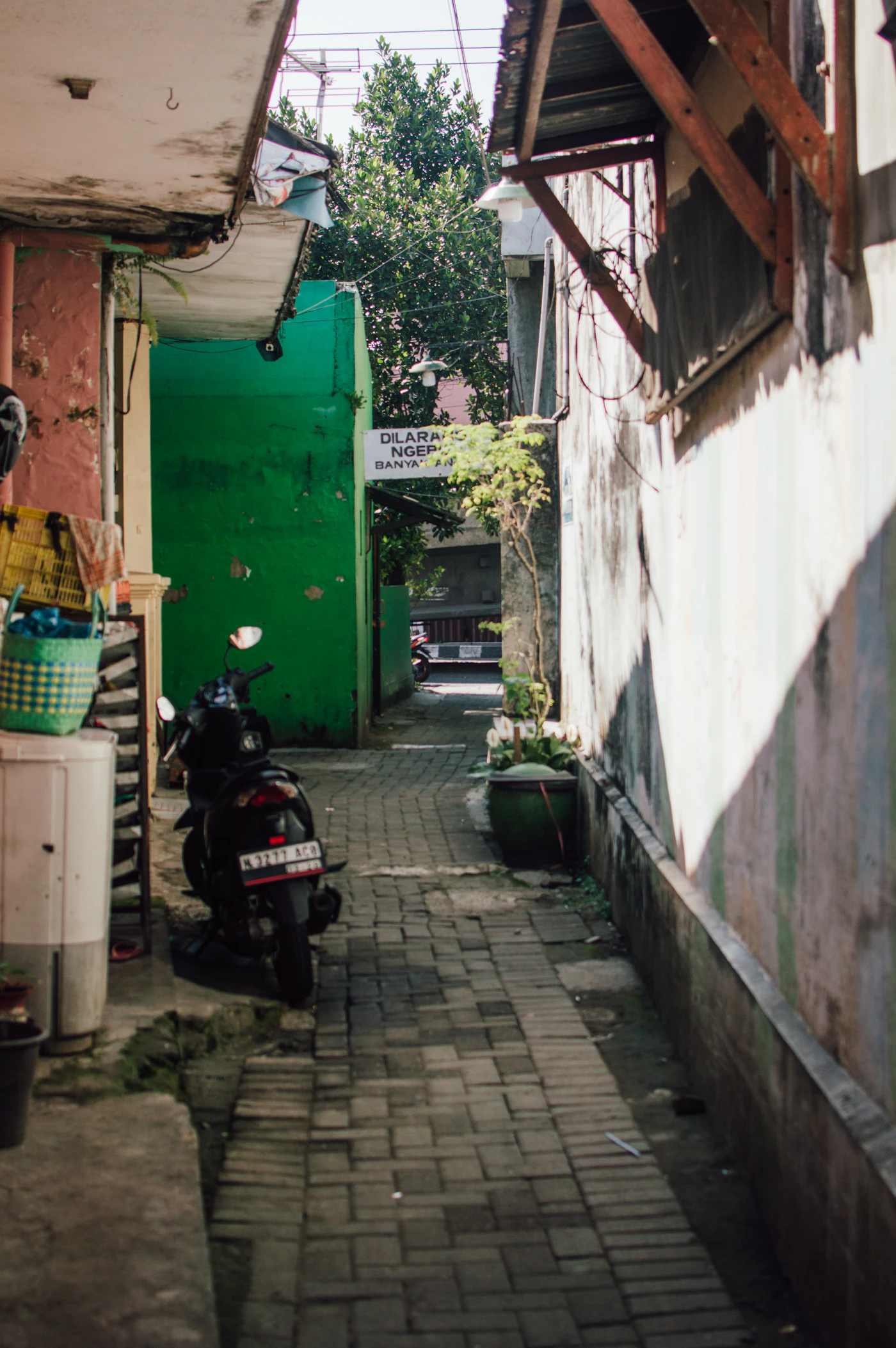 A narrow alley with a moped parked on the side