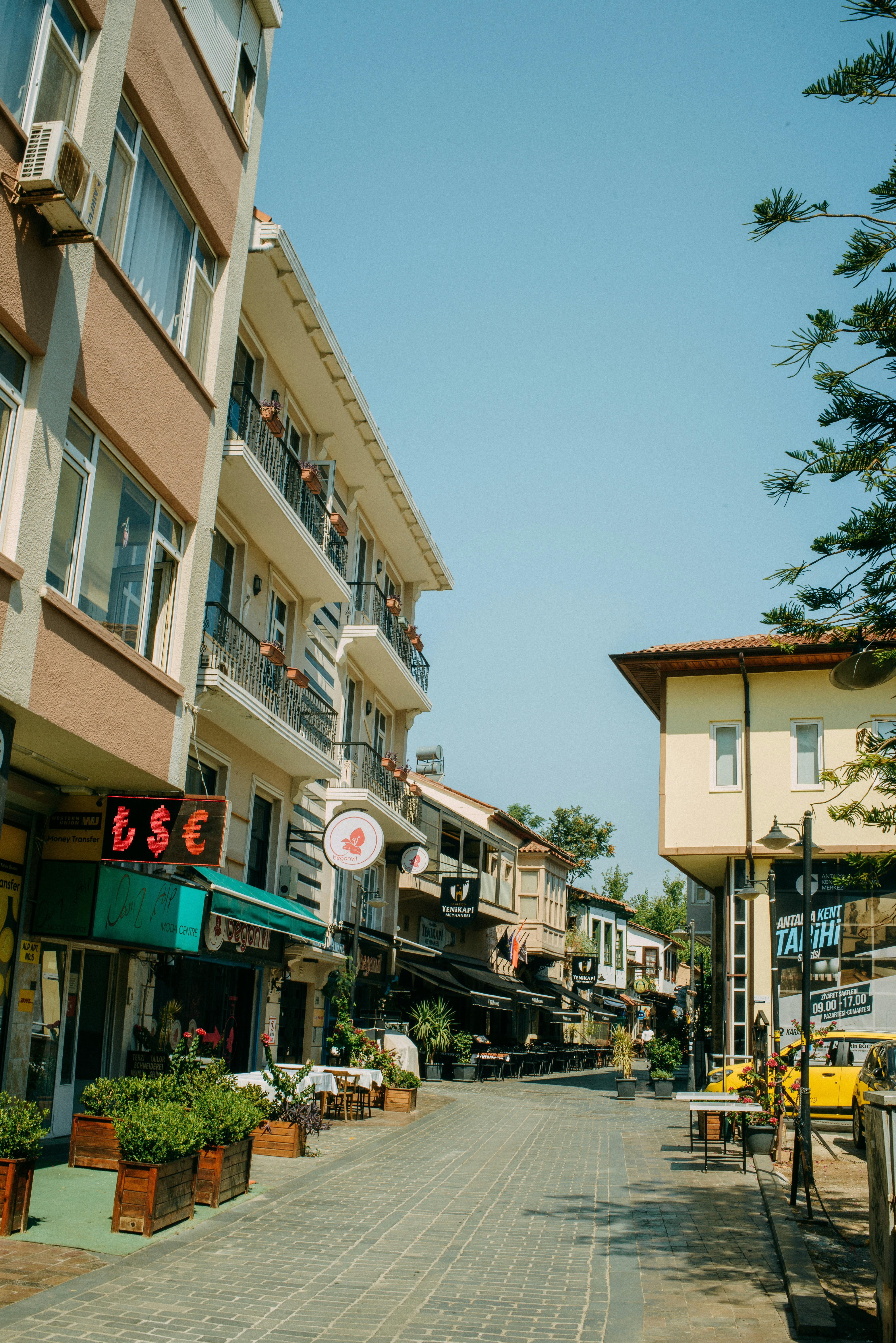 A city street lined with tall buildings and parked cars