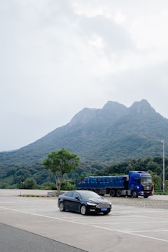 A car parked in a parking lot with a mountain in the background