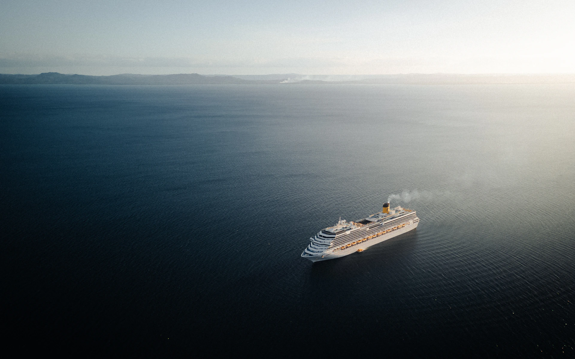 A large white boat floating on top of a large body of water