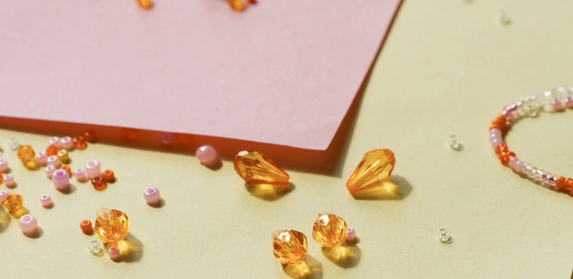 A table with a pink card and some beads