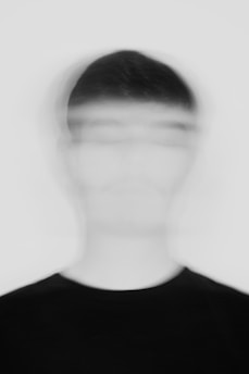 A blurry image of a man in a black shirt