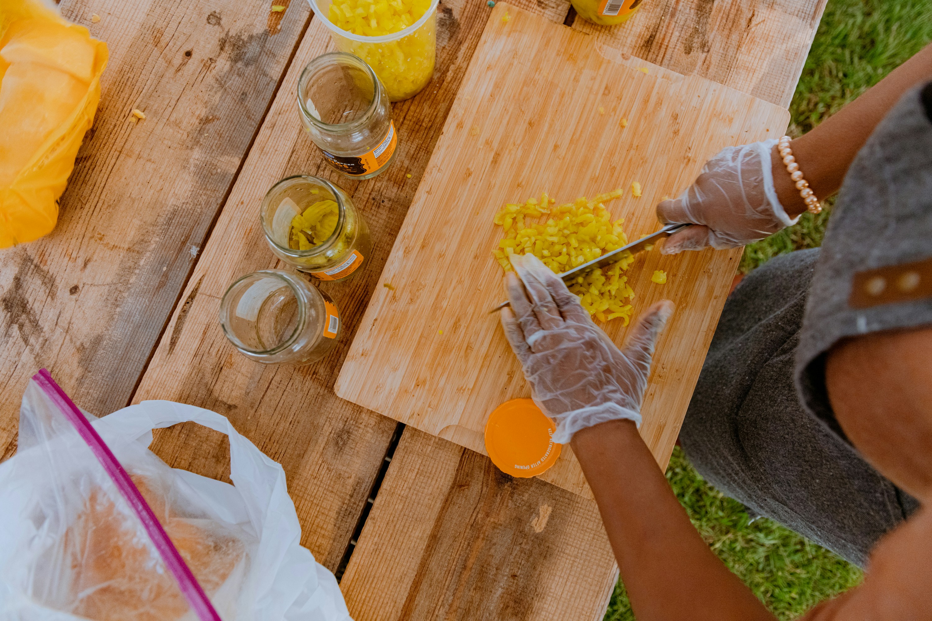 Una persona sentada en una mesa de picnic cortando comida
