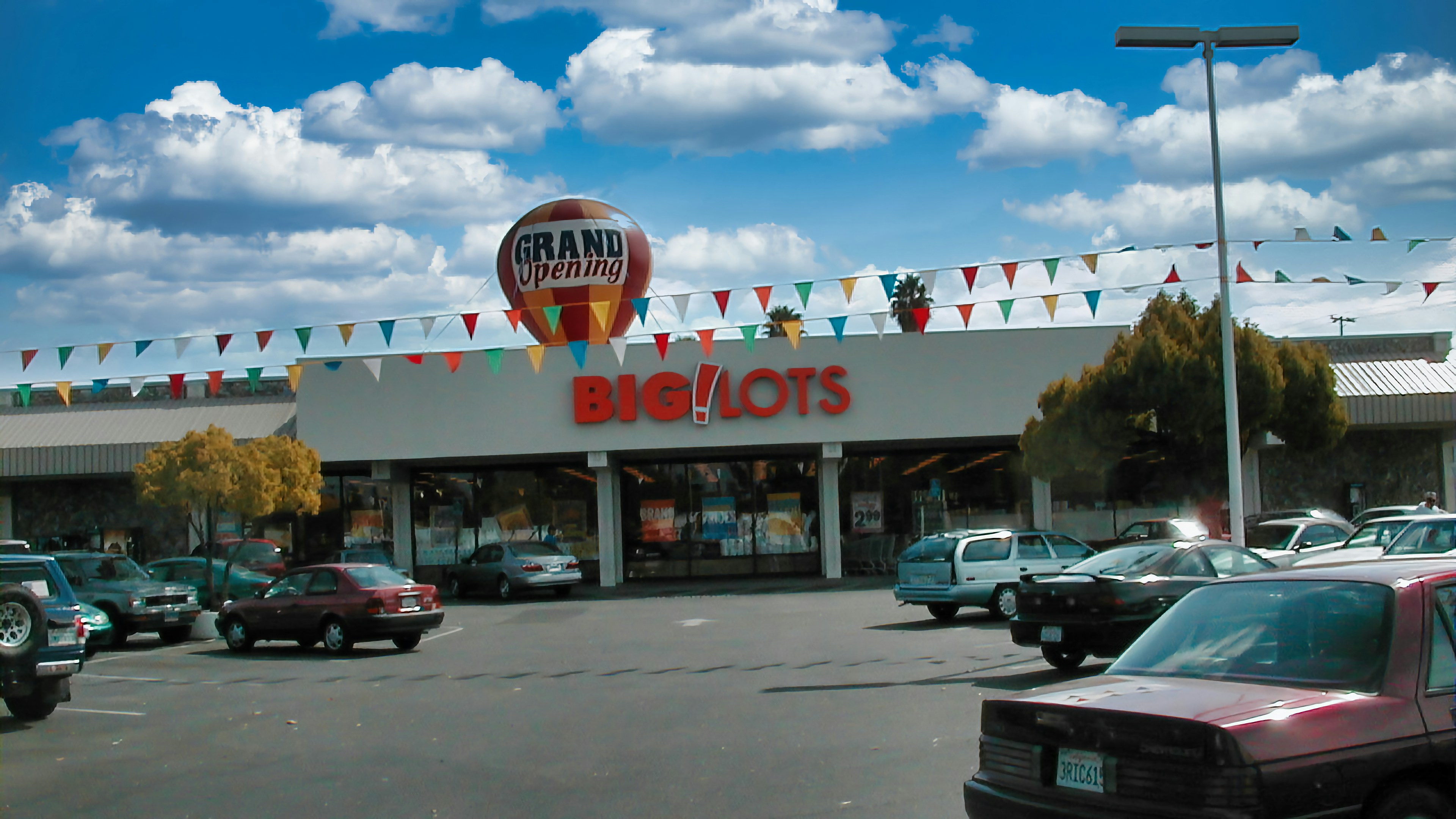 A car is parked in front of a hot air balloon