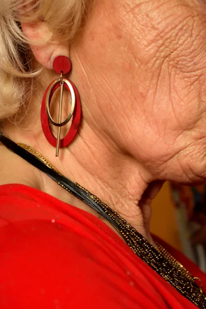 A woman wearing a red dress and a pair of earrings