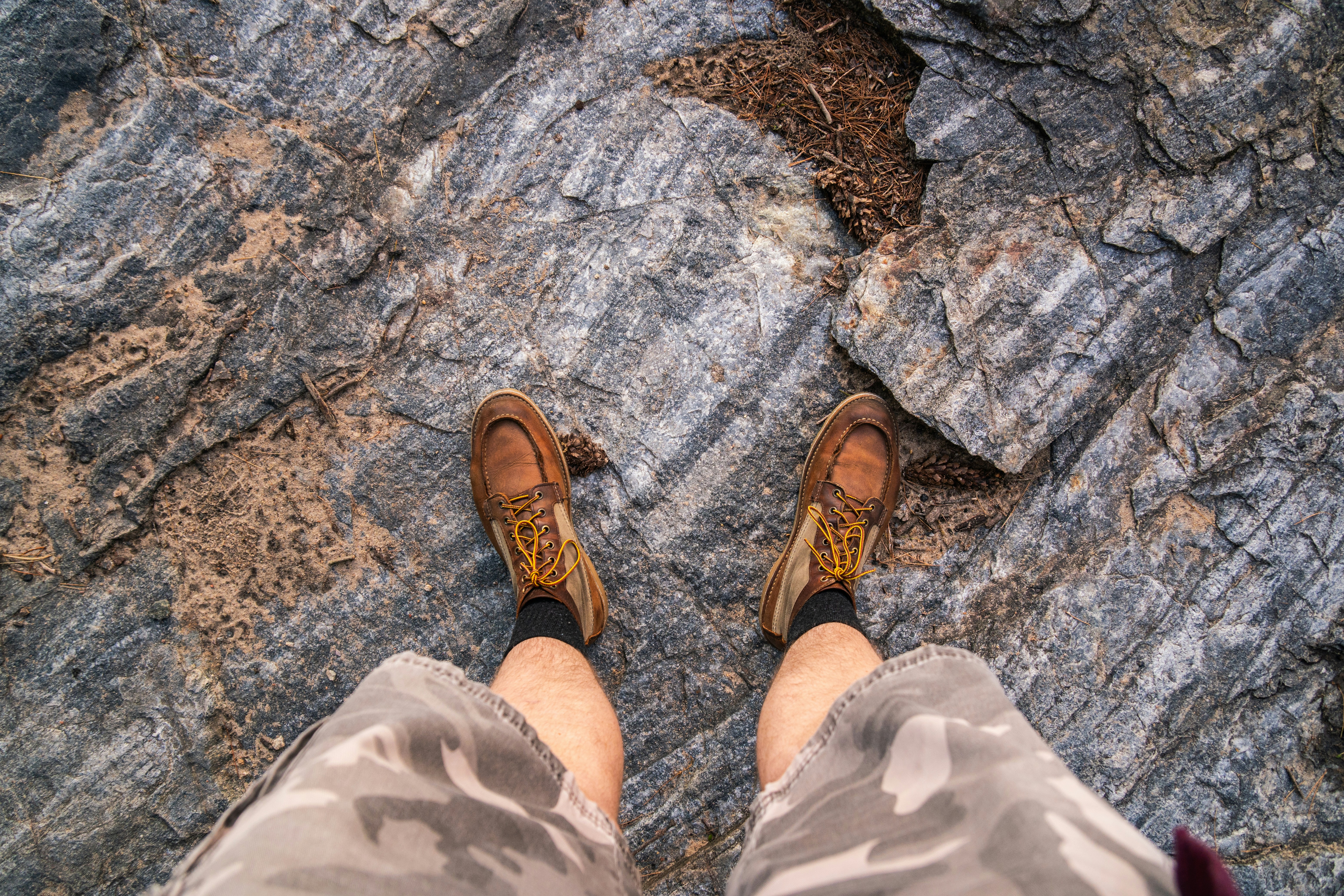 A person standing on top of a large rock